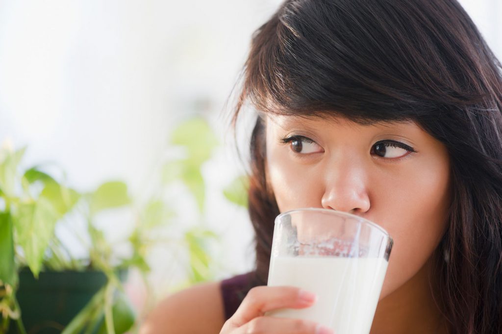 Mulher bebe copo de leite | Osteoporose: coisa de mulher?