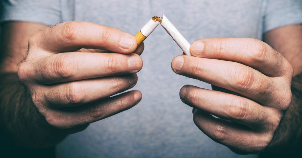 Homem segura as metades de um cigarro em cada uma das mãos | Fatores de risco da osteoporose