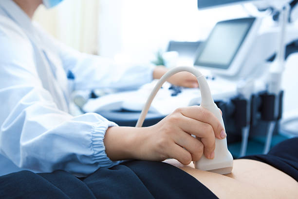 Médico passa o aparelho do exame da ultrassonografia na barriga do paciente | Exame e diagnóstico da endometriose