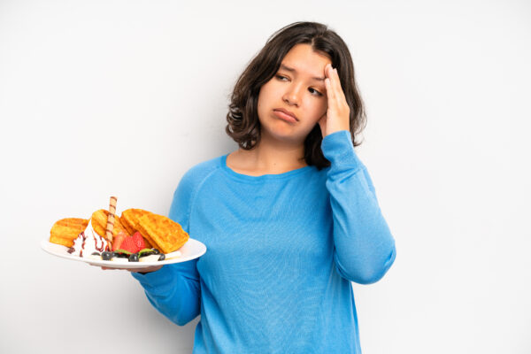 hispanic pretty girl looking happy and pleasantly surprised. waffles breakfast concept
